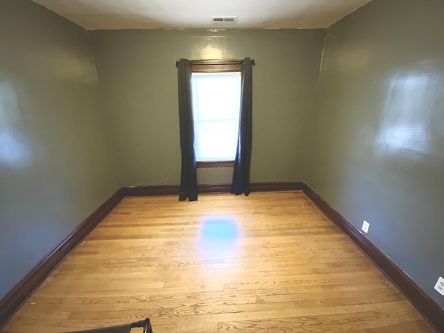 unfurnished room with visible vents, light wood-style flooring, and baseboards