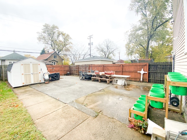 view of patio / terrace with a storage shed, outdoor dining space, an outbuilding, and a fenced backyard