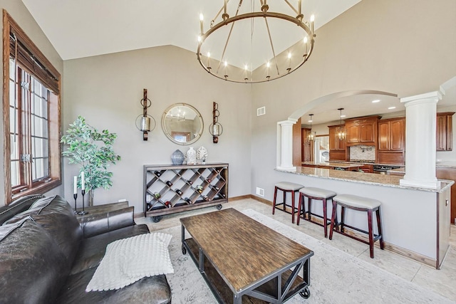 living room featuring high vaulted ceiling and decorative columns