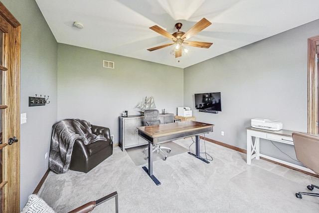 carpeted office space featuring ceiling fan