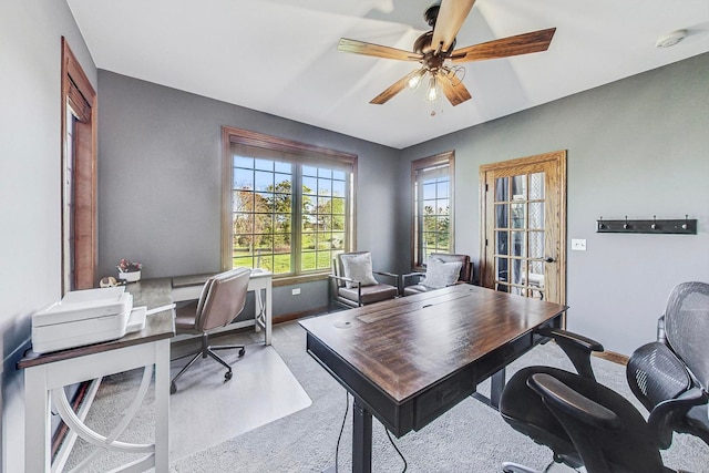 carpeted office space with ceiling fan