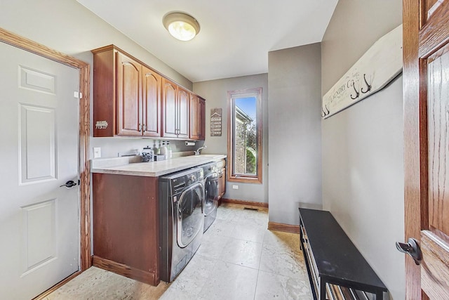 washroom featuring washing machine and dryer, cabinets, and sink