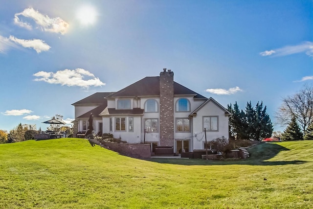 rear view of property featuring a lawn