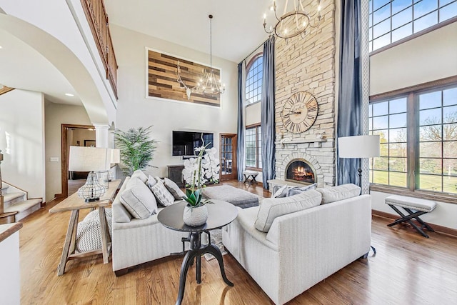 living room featuring a fireplace, a towering ceiling, and hardwood / wood-style flooring