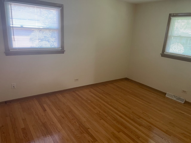 unfurnished room featuring hardwood / wood-style flooring and a wealth of natural light