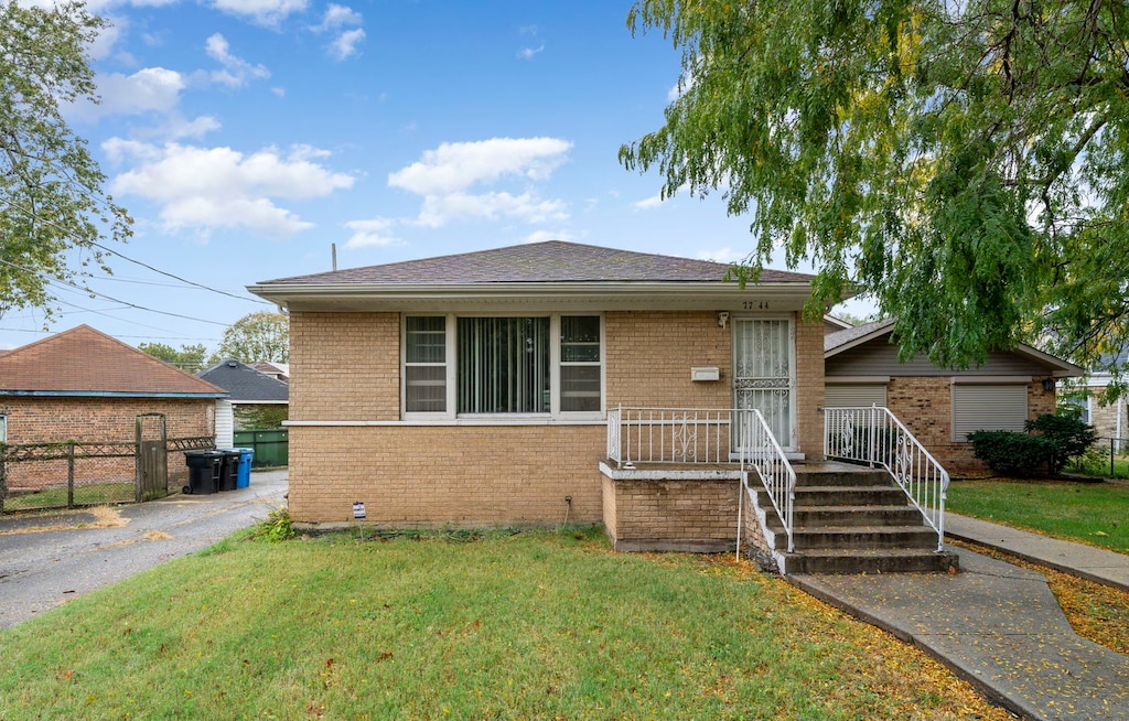 bungalow-style house featuring a front lawn