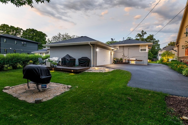 back house at dusk with a wooden deck and a lawn