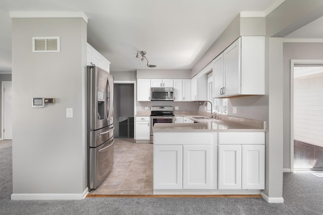 kitchen featuring appliances with stainless steel finishes, white cabinetry, and plenty of natural light