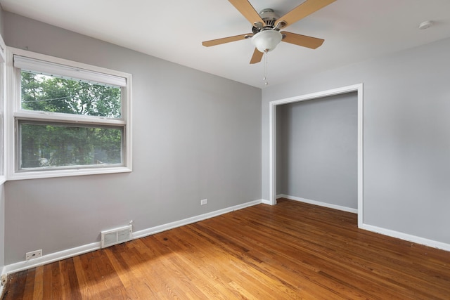 unfurnished bedroom featuring a closet, hardwood / wood-style floors, and ceiling fan