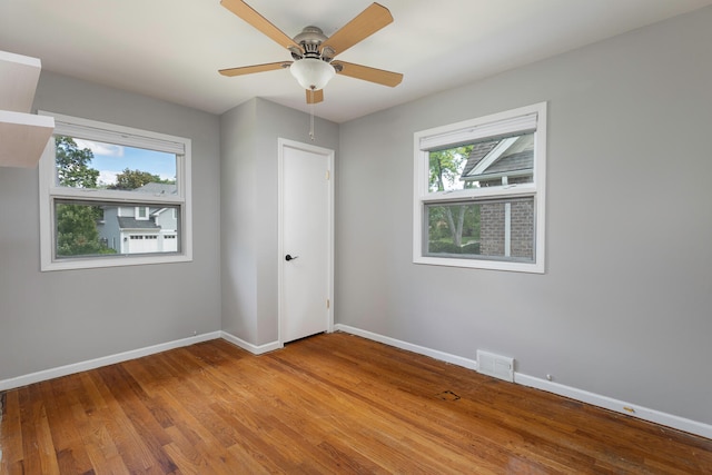 spare room with light hardwood / wood-style flooring, ceiling fan, and a wealth of natural light