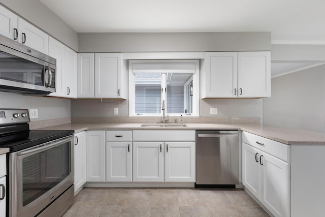 kitchen with ornamental molding, sink, appliances with stainless steel finishes, and white cabinets