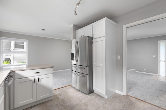 kitchen with appliances with stainless steel finishes, white cabinets, and light colored carpet