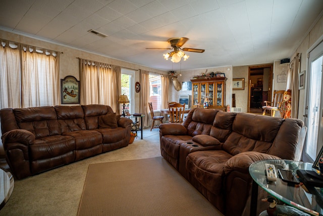 carpeted living room featuring ceiling fan and crown molding