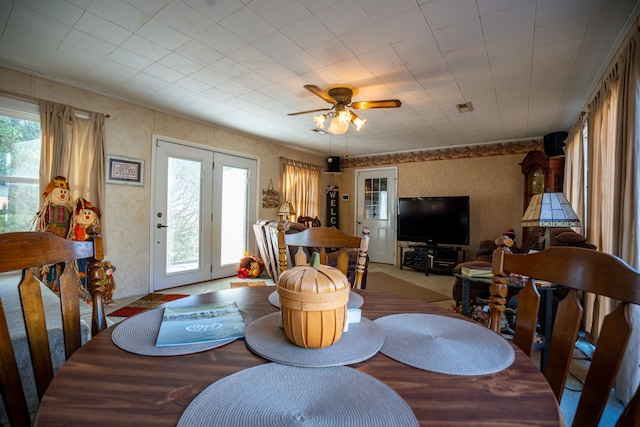 carpeted dining room featuring ceiling fan and a healthy amount of sunlight