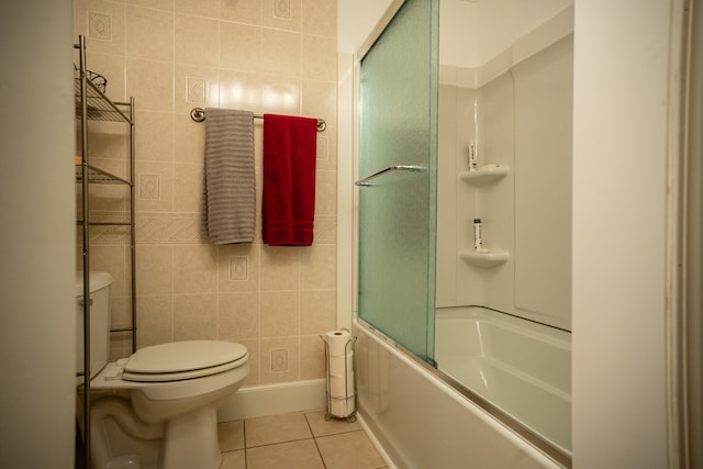 bathroom featuring toilet, tile walls, tile patterned floors, and enclosed tub / shower combo