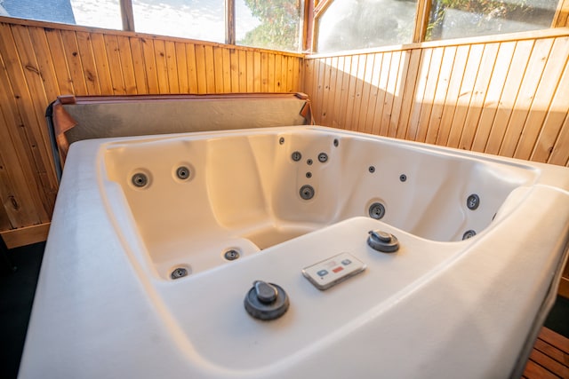 bathroom featuring a tub to relax in and wooden walls