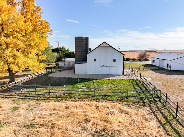 view of yard with an outdoor structure and a rural view