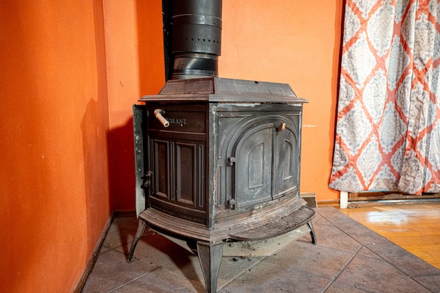 details featuring a wood stove and wood-type flooring