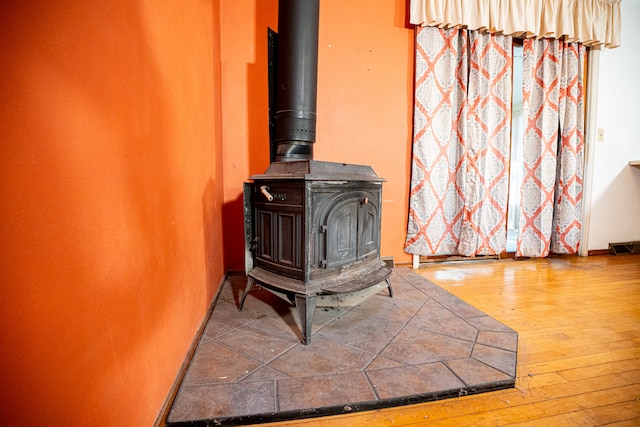 interior details featuring hardwood / wood-style floors and a wood stove