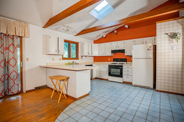 kitchen with kitchen peninsula, white cabinets, and white appliances