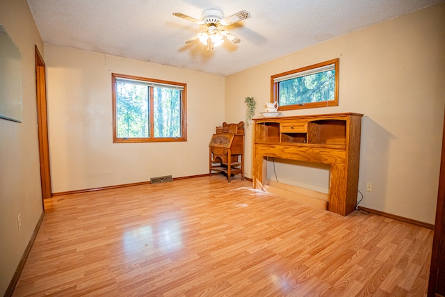 interior space with ceiling fan, light hardwood / wood-style floors, and a textured ceiling