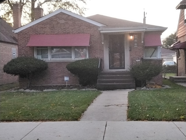 bungalow-style home with a front lawn