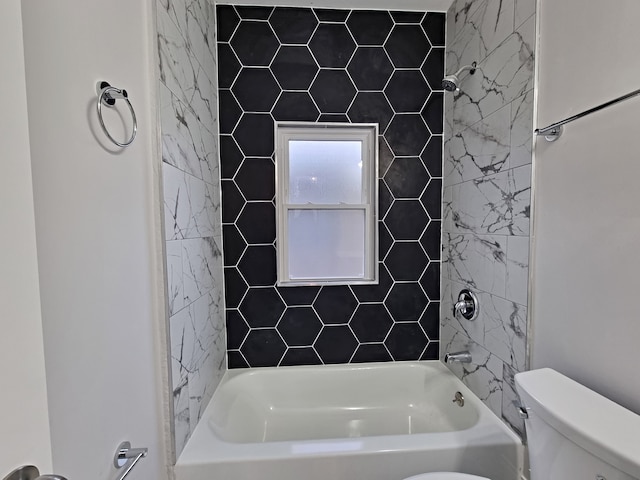 bathroom with toilet and tiled shower / bath