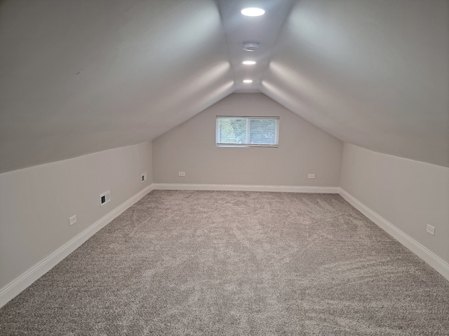 additional living space featuring carpet floors and vaulted ceiling