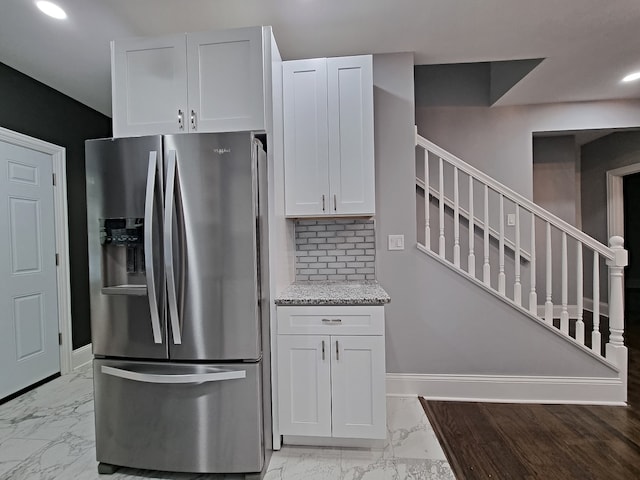 kitchen with white cabinets, tasteful backsplash, and stainless steel fridge with ice dispenser