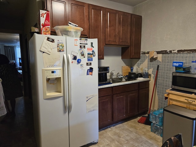 kitchen with sink, white refrigerator with ice dispenser, and dark brown cabinets