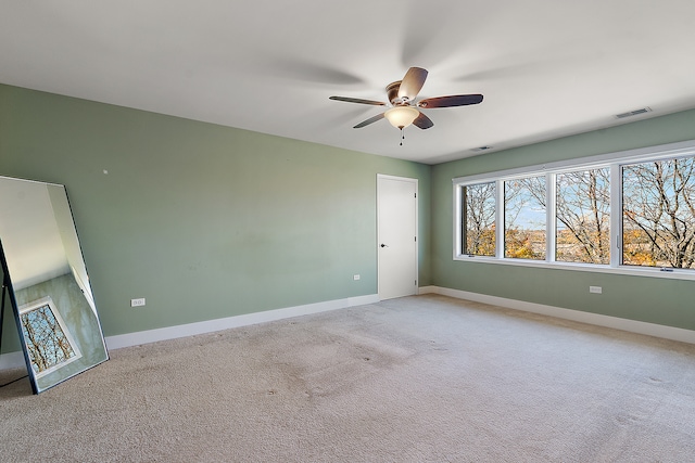 carpeted spare room featuring ceiling fan