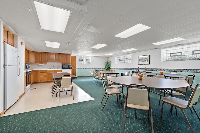 dining area featuring a paneled ceiling and sink