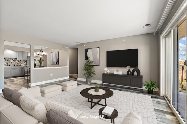 living room with light hardwood / wood-style flooring and a notable chandelier