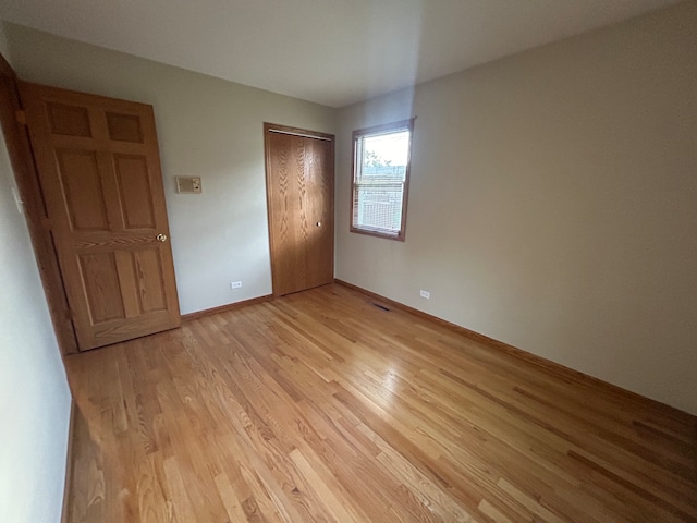 unfurnished bedroom with a closet and light hardwood / wood-style flooring