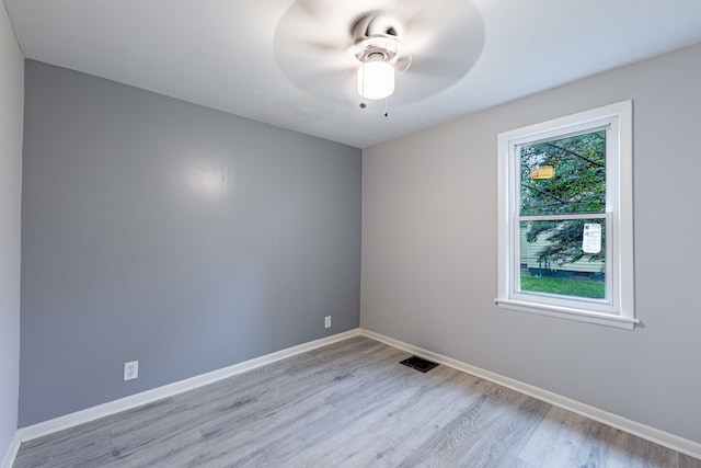 empty room with ceiling fan and light hardwood / wood-style flooring