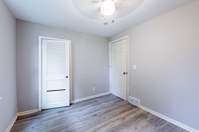 unfurnished bedroom with ceiling fan, a closet, and light hardwood / wood-style flooring