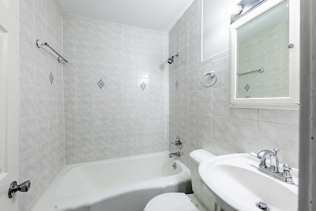 full bathroom featuring toilet, tile walls, sink, and tiled shower / bath