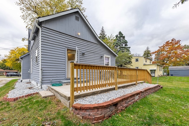 back of house with a wooden deck and a yard