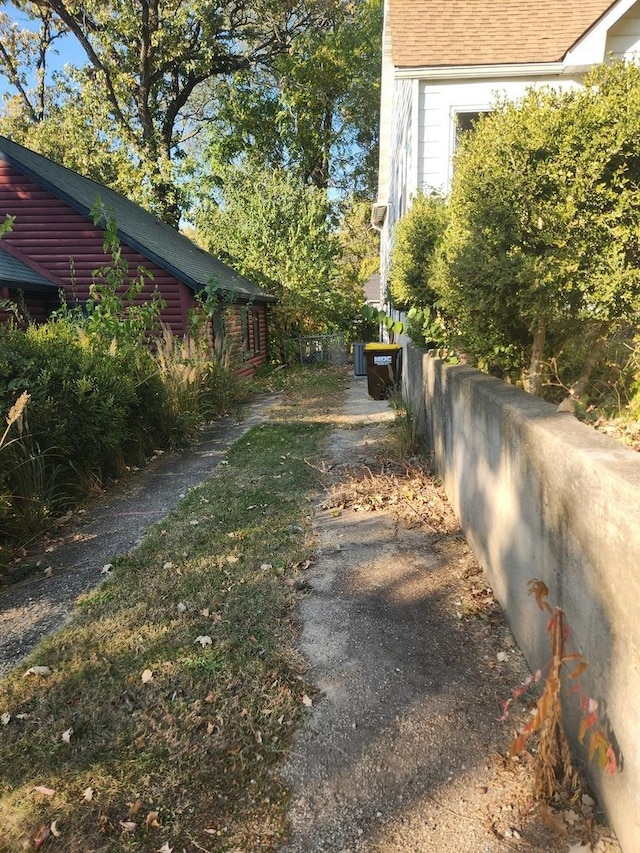 exterior space with fence and roof with shingles