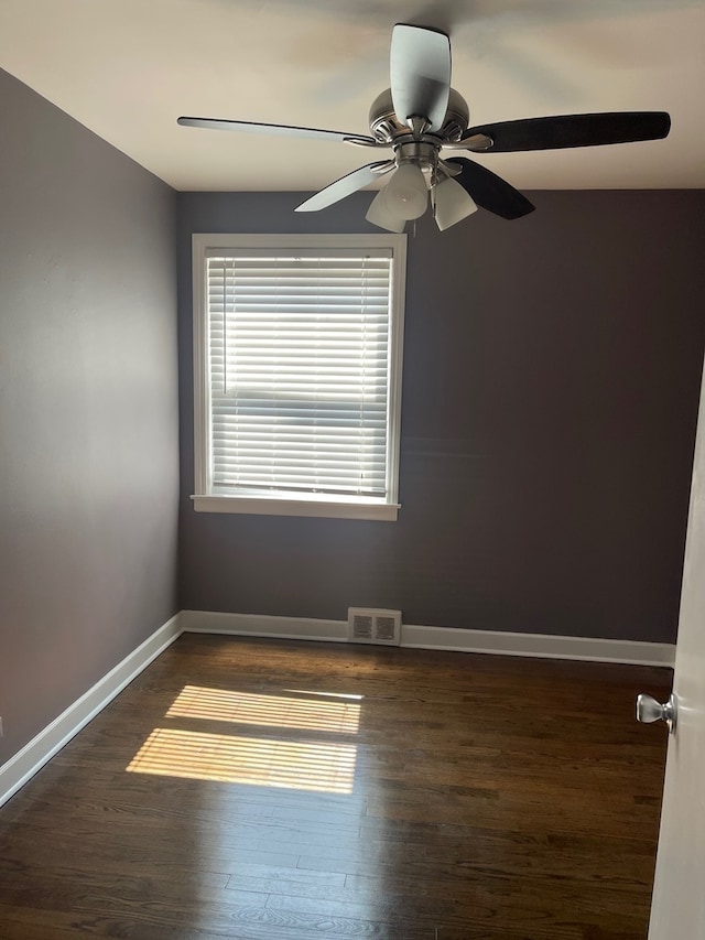 spare room featuring dark wood-type flooring and ceiling fan