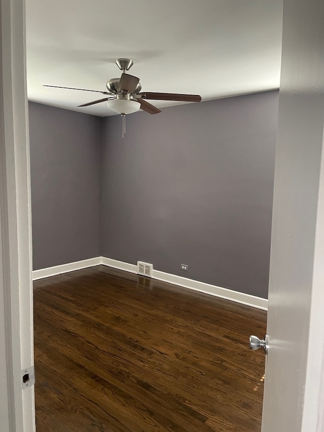 unfurnished room featuring dark wood-type flooring and ceiling fan