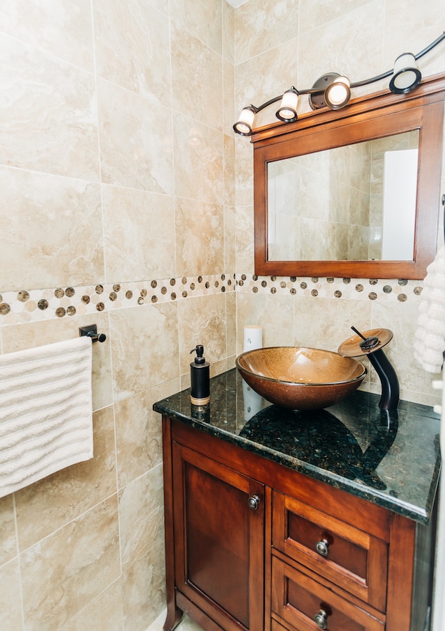 bathroom featuring vanity, tasteful backsplash, and tile walls