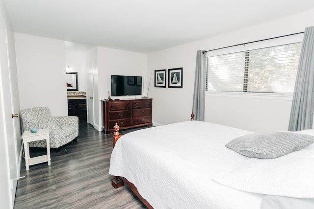 bedroom featuring dark wood-type flooring and ensuite bath