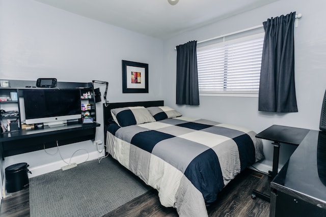 bedroom with dark hardwood / wood-style floors