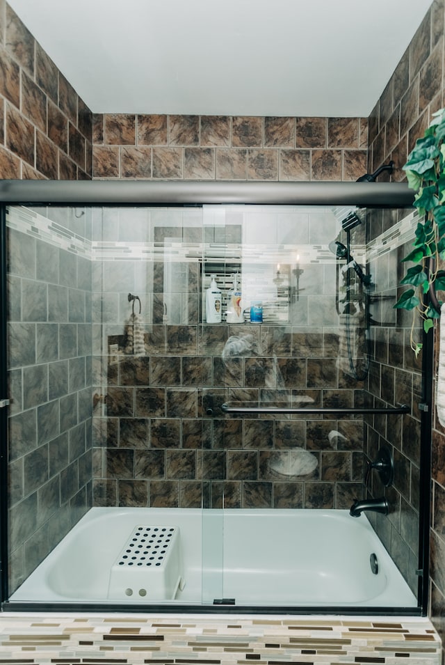 bathroom with bath / shower combo with glass door