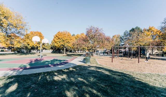 view of property's community with a playground, basketball court, and a lawn