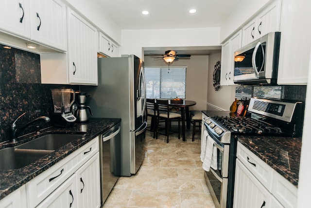 kitchen with backsplash, sink, white cabinetry, appliances with stainless steel finishes, and ceiling fan