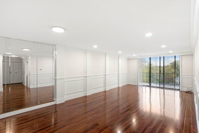 unfurnished room featuring ornamental molding and dark wood-type flooring