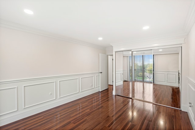 unfurnished bedroom featuring dark wood-type flooring, access to outside, ornamental molding, and a closet