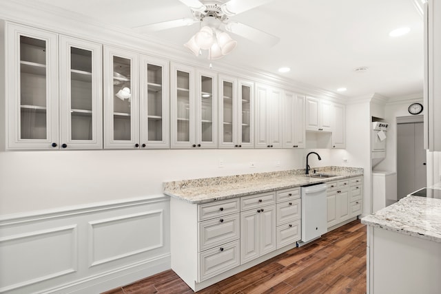 kitchen featuring stacked washing maching and dryer, white cabinets, dishwasher, and dark hardwood / wood-style flooring